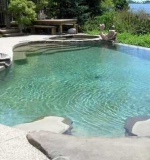 A – Freeform pool with vanishing edge overlooking the bay. Attached spa, custom walk-in stairs and sun shelf area.