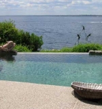 Freeform pool with vanishing edge overlooking the bay. Attached spa, custom    walk-in stairs and sun shelf area.