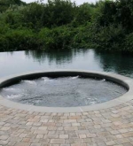 Beach entry pool with spa and vanishing edge.