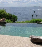 Freeform pool with vanishing edge overlooking the bay. Attached spa, custom    walk-in stairs and sun shelf area.