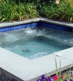 10' x 10' gunite spa with a stone veneer exterior with bluestone coping and automatic cover.